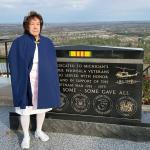 Stolze stands at the Vietnam War Memorial on top of Pine Mountain. She is dressed in the Upper Peninsula Nurses Honor Guard’s traditional white uniform, cap, and blue and red cape. (Terri Castelaz/Daily News photo)