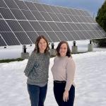 Jes Thompson (left) and Anna Solberg in front of the solar array on campus.