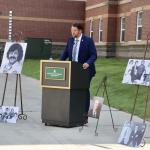 Jeff Korpi speaks at the dedication, surrounded by photos of Holm.